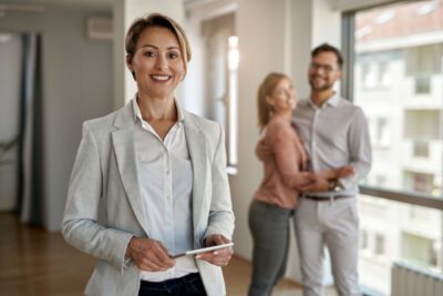 couple and real estate agent smiling