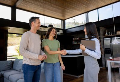 Real estate agent handshaking with a couple of customers