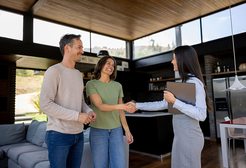 real estate agent handshaking with a couple of customers and discussing on how they will sell their house fast in southern california