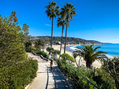 Young girl walks her dog along path in Laguna Beach in Southern California